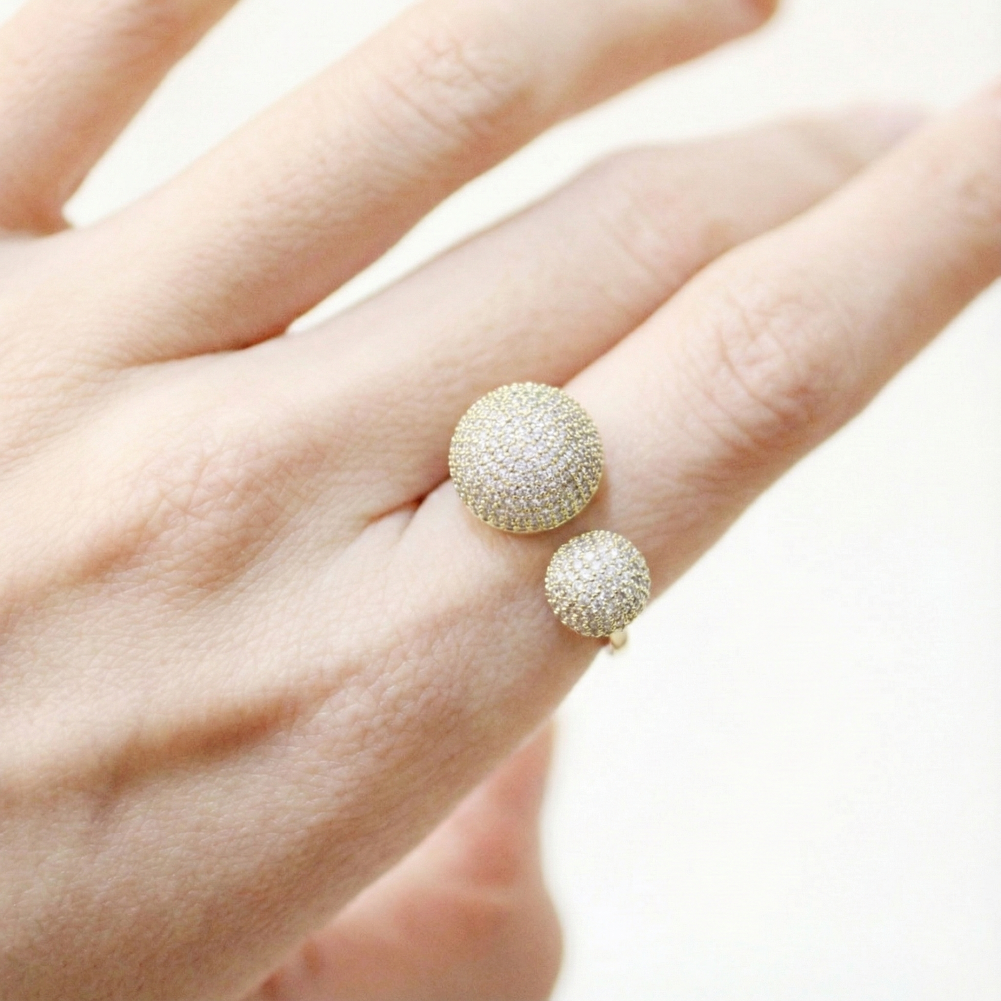 Gold crystal dome open ring worn on hand, showcasing bold double sphere design