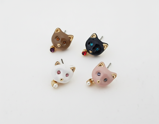 Four enamel cat stud earrings displayed on a white background—white with pearl drop, pink with pearl drop, brown with purple crystal drop, and black with red crystal drop.
