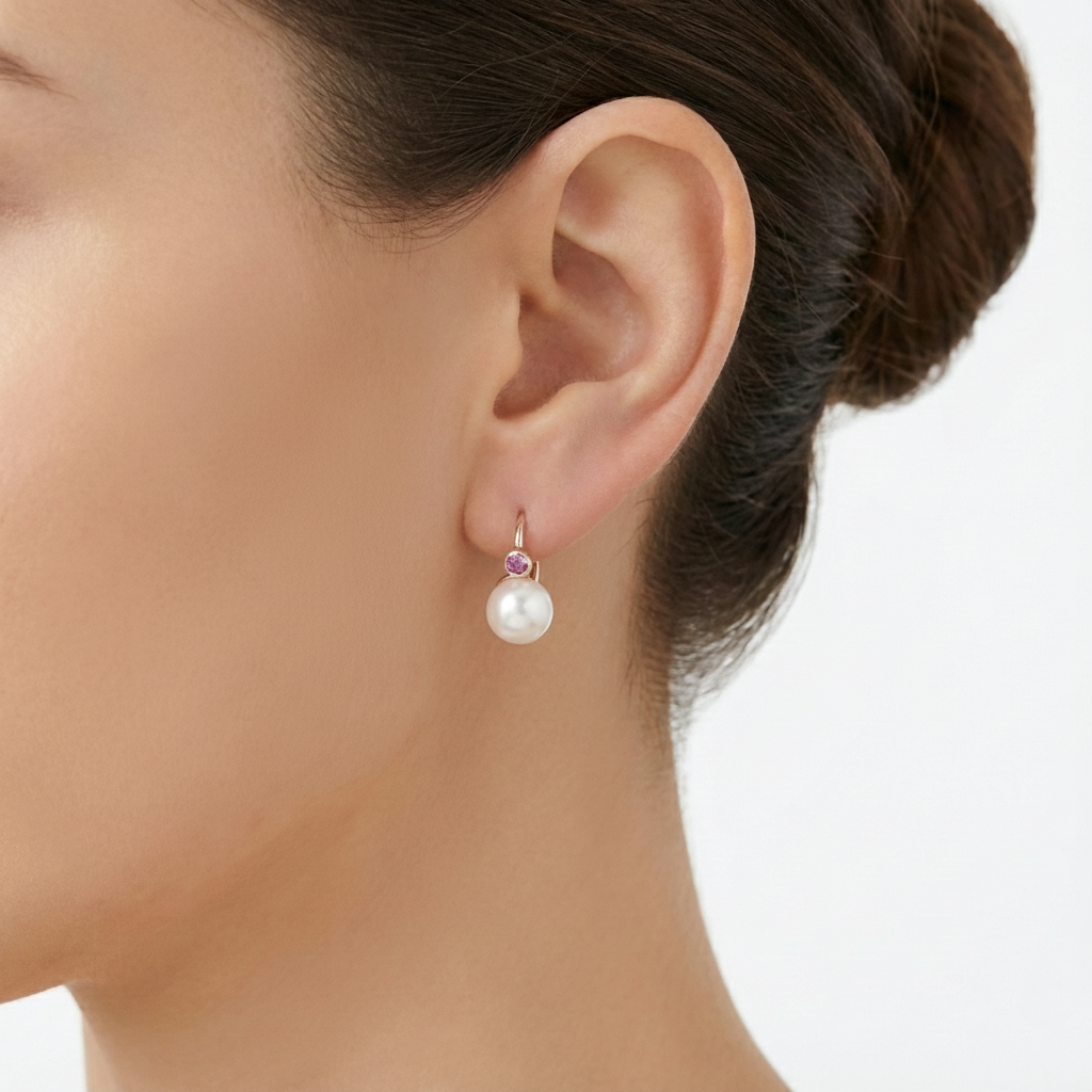 Model wearing a pink cubic and pearl drop earring with rose gold hook on left earlobe.