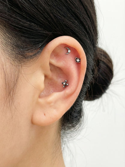 minimal ear styling with silver gothic barbell studs featuring moon, star, and cross designs, surgical steel