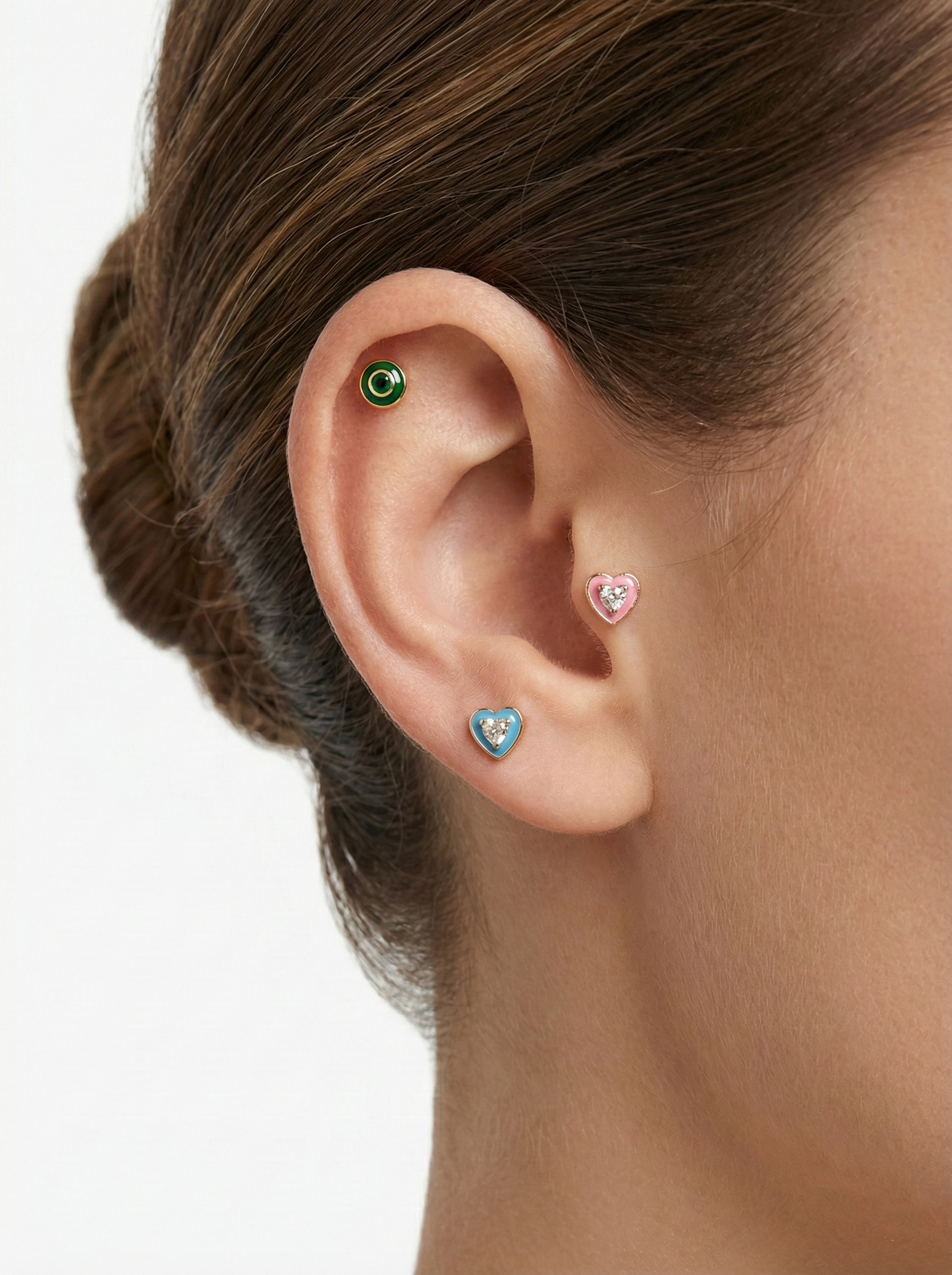 Model wearing a small green cubic epoxy barbell ball earring on inner conch