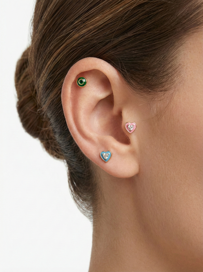 Model wearing a small green cubic epoxy barbell ball earring on inner conch