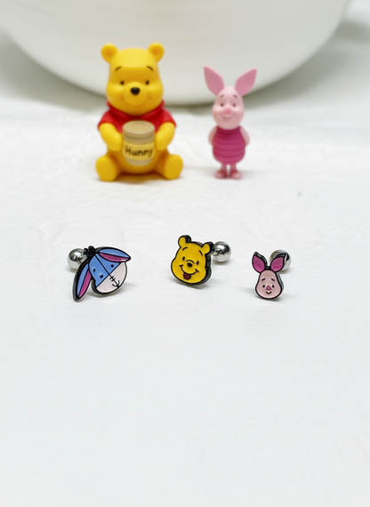 Eeyore, Pooh, and Piglet barbell earrings shown with matching figurines on a white background.