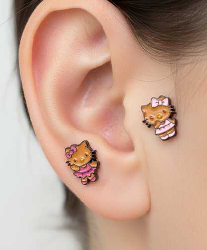 Adorable Hello Kitty–inspired piercing featuring a playful Hawaii-style cat in pink or red dress. Made with hypoallergenic surgical steel. Sold as single.