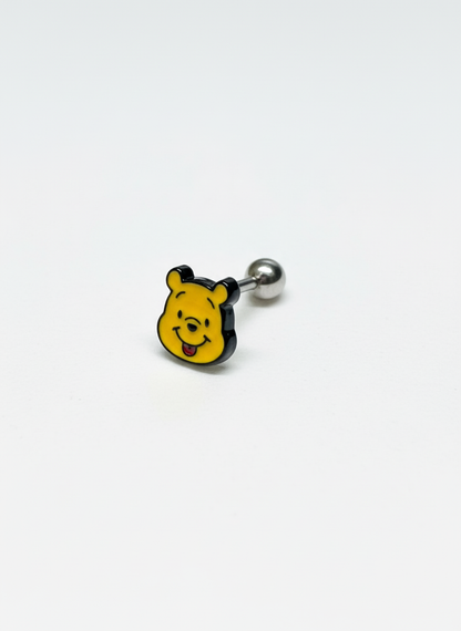 Close-up of a Pooh face barbell earring on a white surface with silver post visible