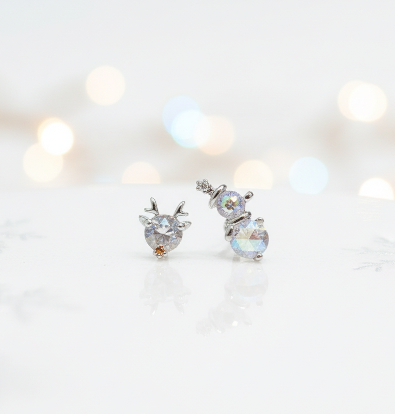 Aurora crystal snowman & reindeer barbell-ball earrings on frosty winter background — surgical steel Christmas jewelry product shot