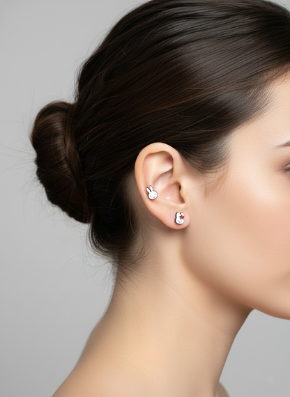Lifestyle photo showing two Miffy earrings — one with a red flower, one plain — styled on a model’s ear in a stacked arrangement; clean, minimal lighting.