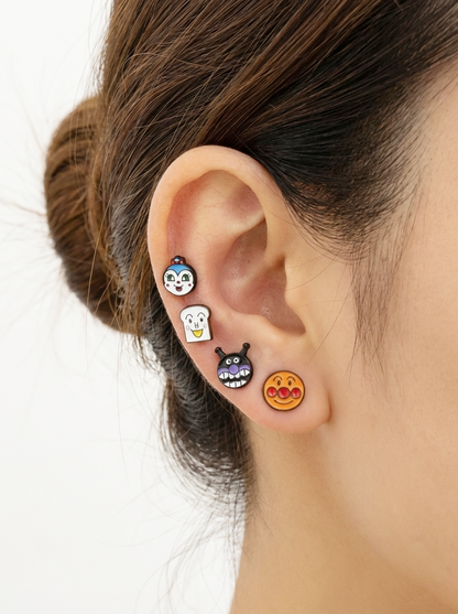 Woman's ear with all four Anpanman character earrings worn in a vertical line.