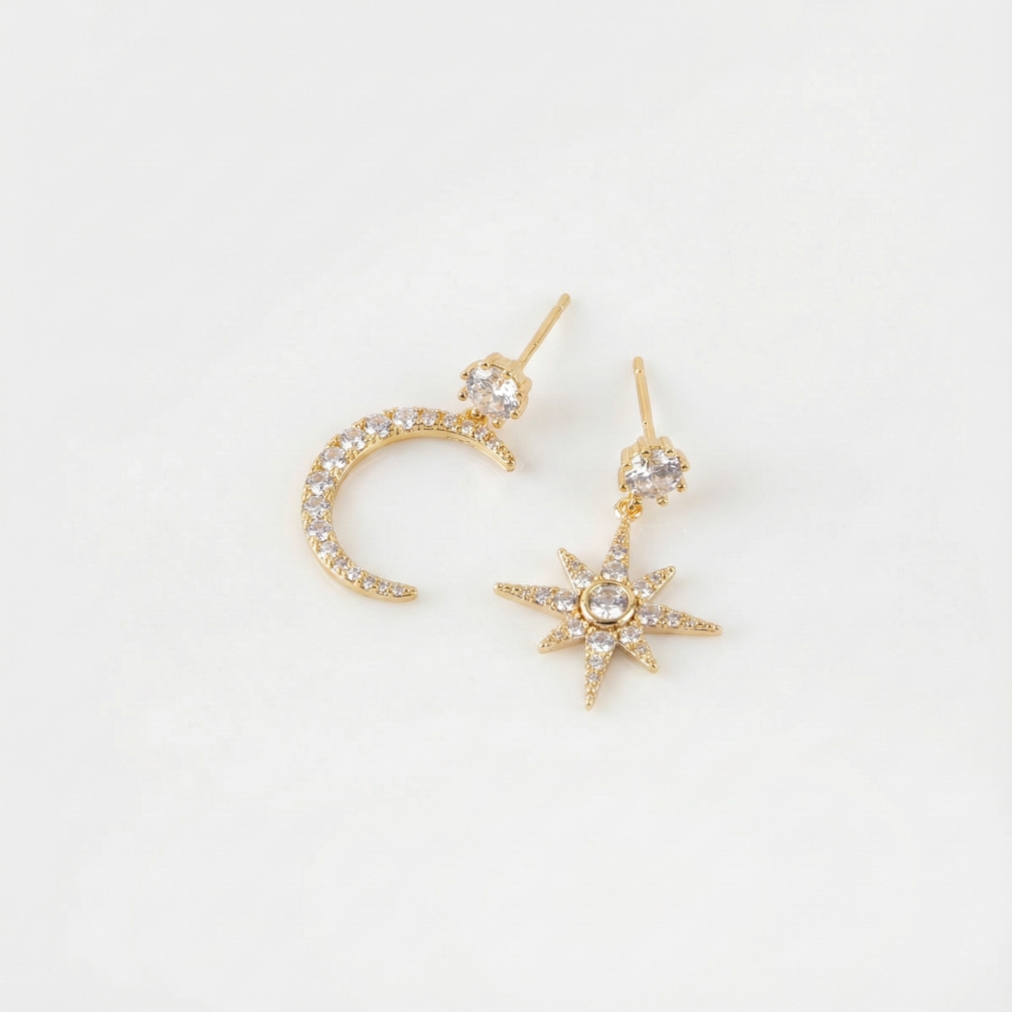 Flat lay of gold moon and north star earrings