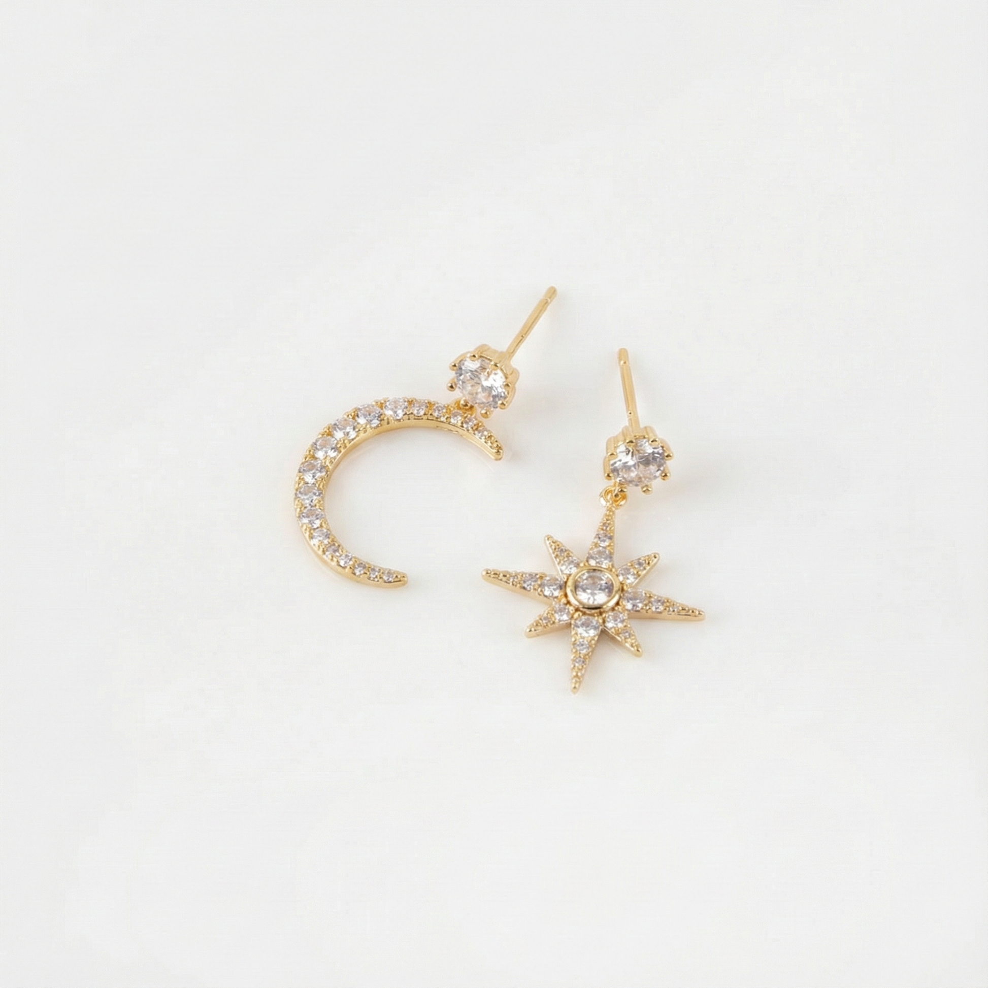 Flat lay of gold moon and north star earrings