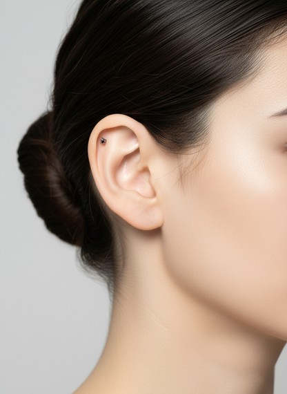 Side profile showing a single minimalist barbell on the inner cartilage. The ear is clean and unadorned, emphasizing a simple, modern vibe.