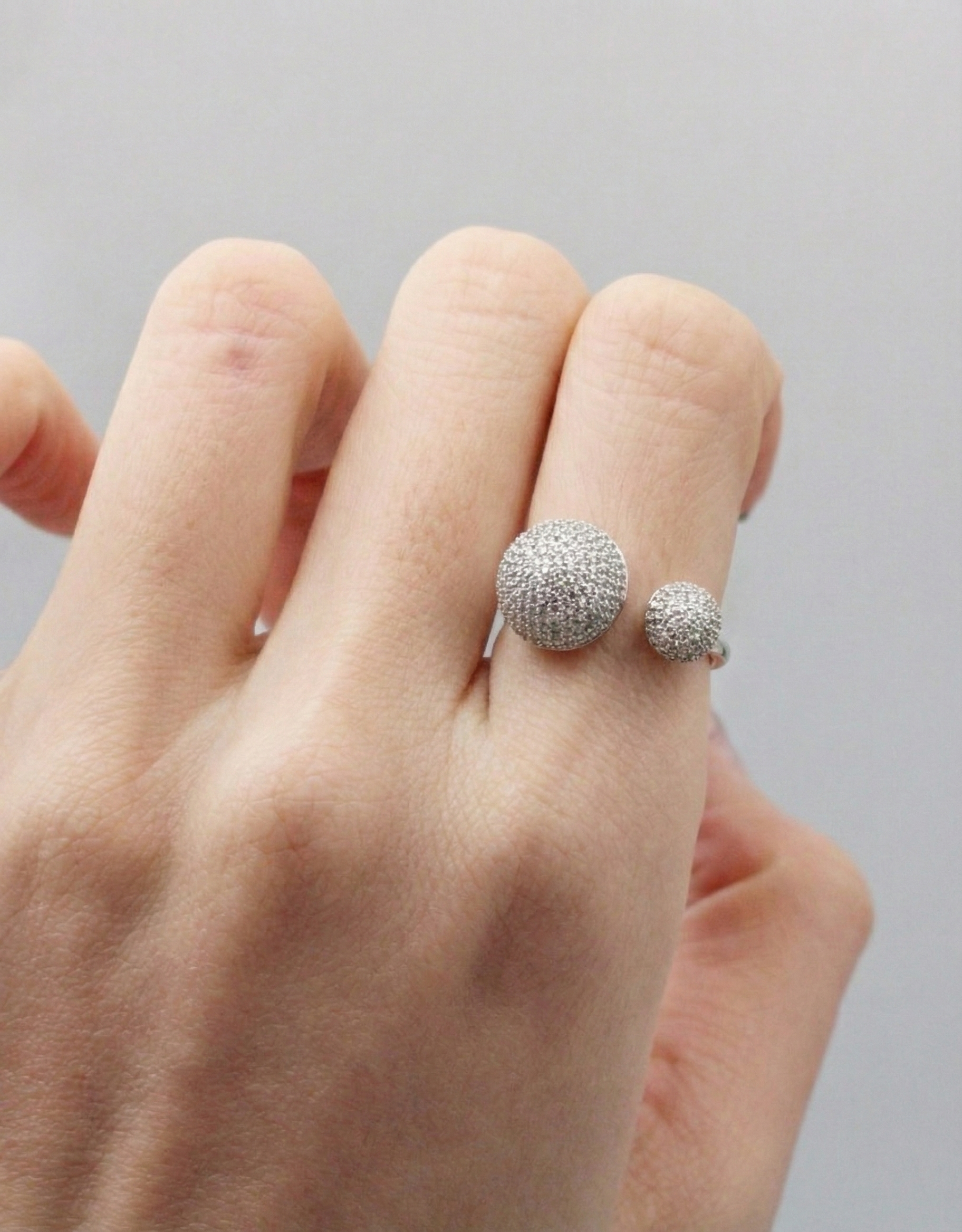Silver double dome ring with sparkling pave finish, styled on hand with natural nails