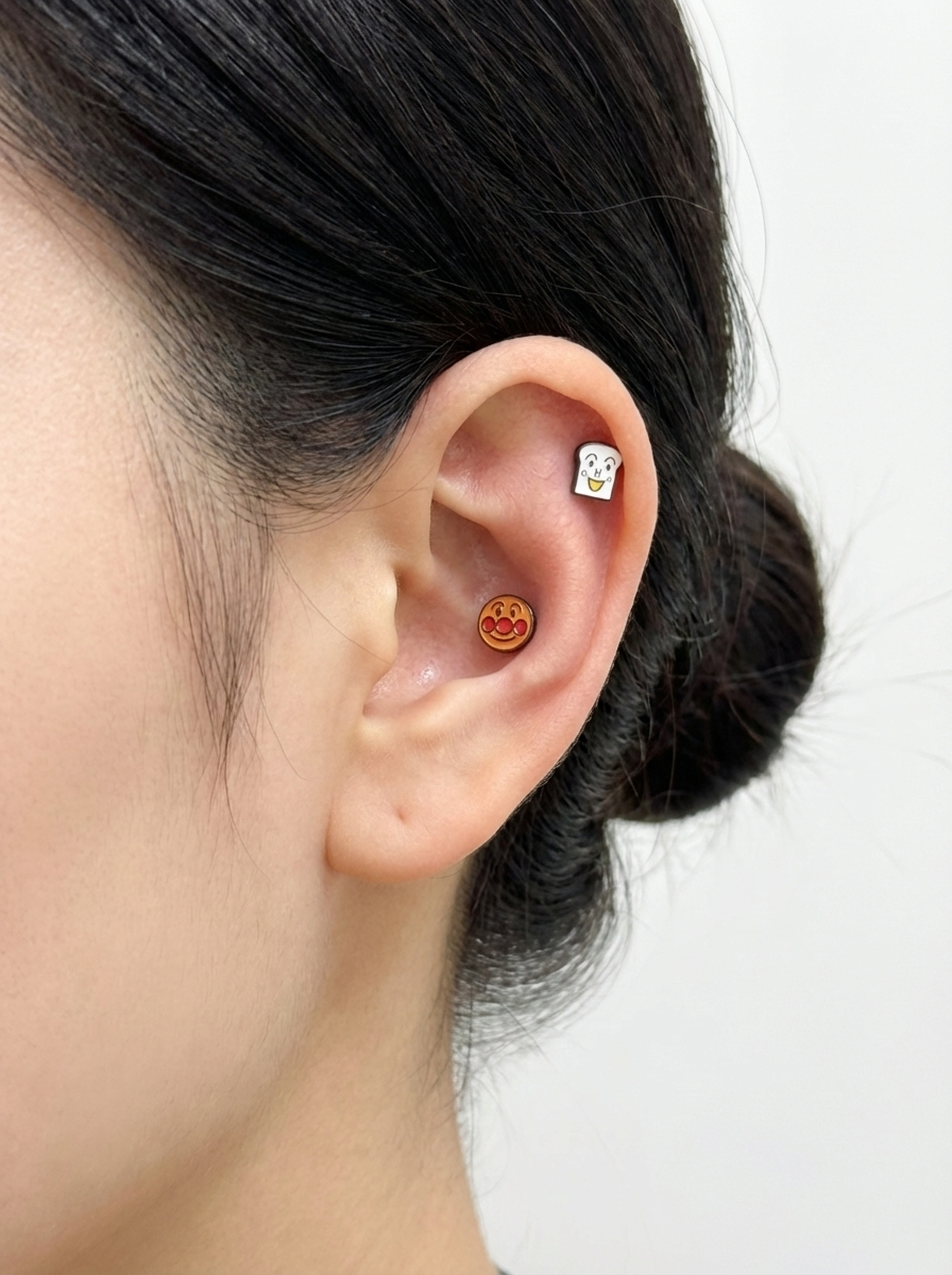Two-character ear styling with Anpanman and Shokupanman studs in close-up.