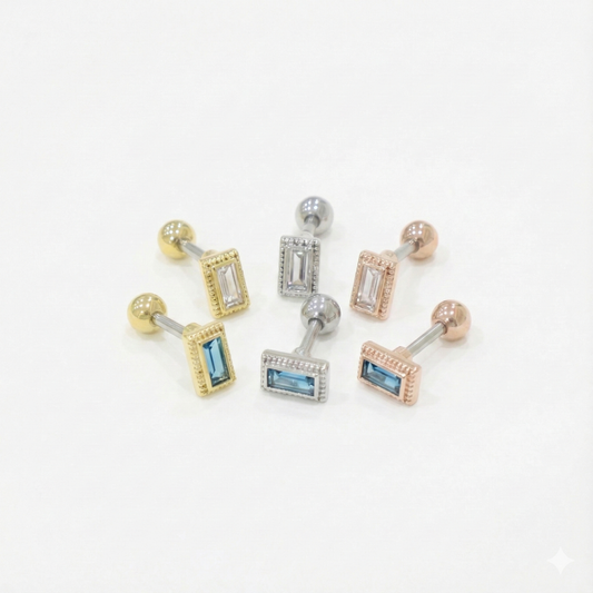 A set of six barbell earrings featuring rectangular CZ stones in clear and blue, with gold, silver, and rose gold bezel settings.