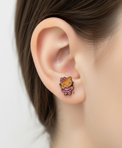 Adorable Hello Kitty–inspired piercing featuring a playful Hawaii-style cat in pink or red dress. Made with hypoallergenic surgical steel. Sold as single.