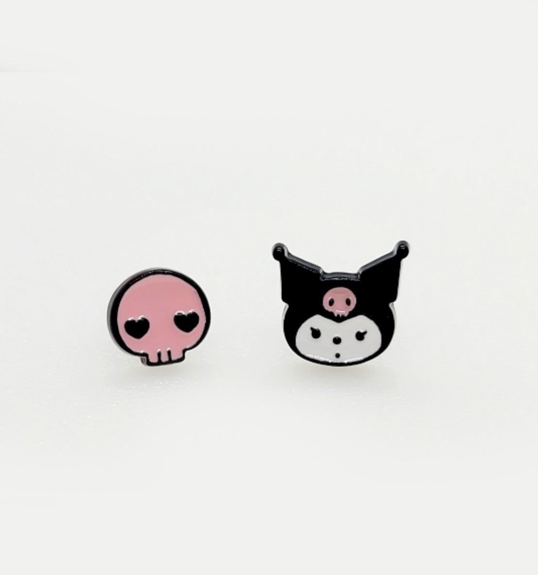 Pink skull with heart eyes and Kuromi face enamel stud earrings on white background, playful goth kawaii mismatched pair, black and pink Sanrio character design, 925 silver posts hypoallergenic, Korean handmade jewelry