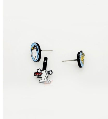 Flat-lay of two post-back earrings — Snoopy in a helmet with dangling body piece, and Woodstock in a matching helmet — placed on a white surface.