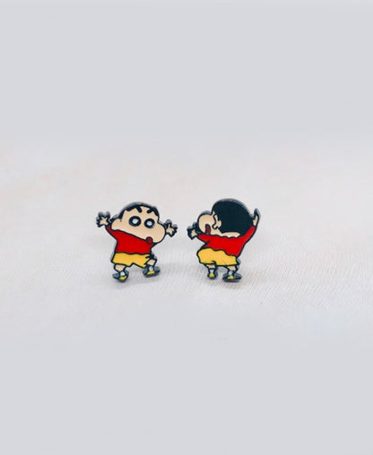 Crayon Shin-chan inspired child figure stud earrings in red tops and yellow shorts, shown on a fabric surface with front and back poses.