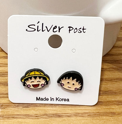 Front view of Chibi Maruko-chan enamel earrings showing yellow hat and bob haircut designs
