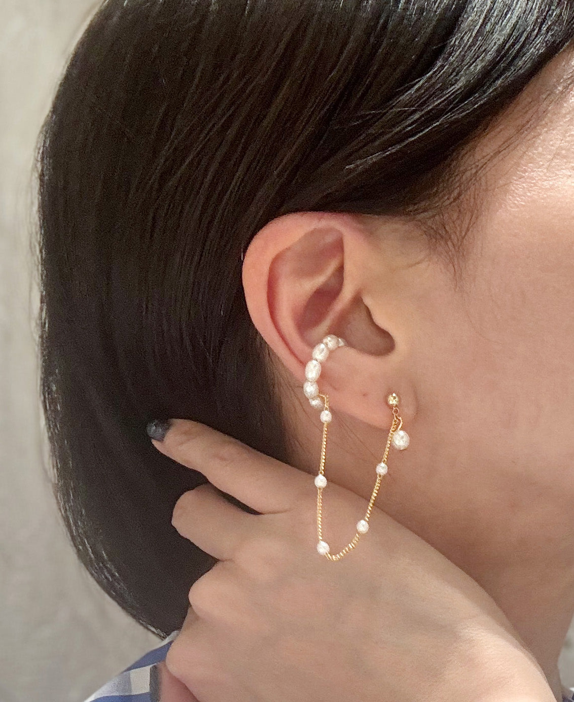 Gold pearl ear cuff worn on model - side view