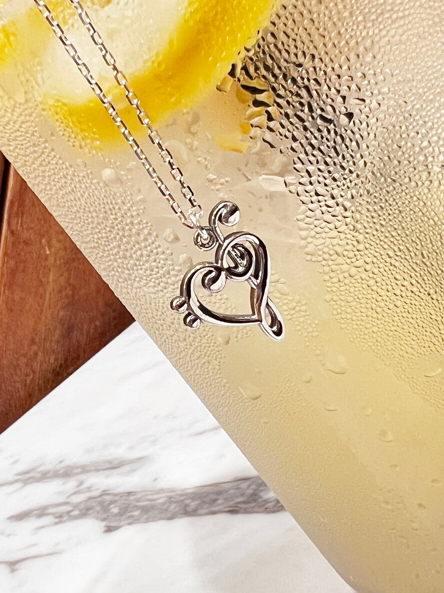 Heart-shaped music note pendant close-up detai