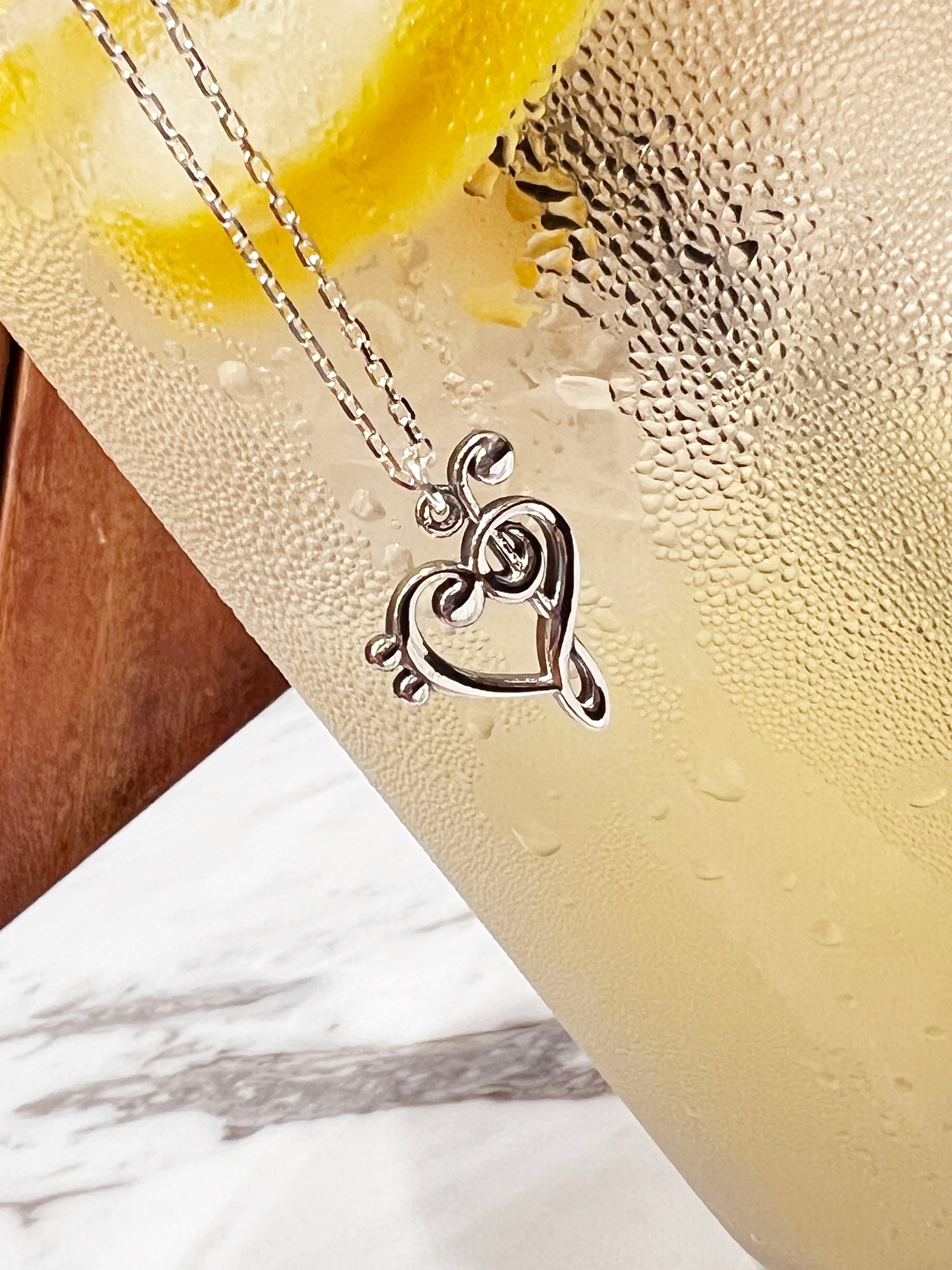 Heart-shaped music note pendant close-up detai