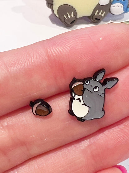 Hand holding miniature Totoro Catbus Soot Sprite earrings showing size comparison