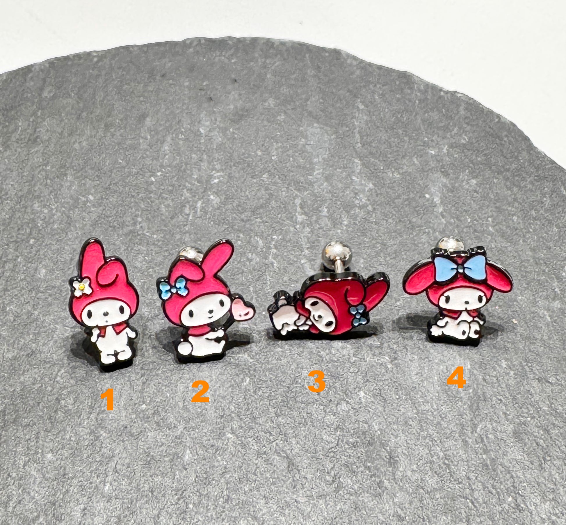 Four My Melody inspired barbell earrings showing different character expressions