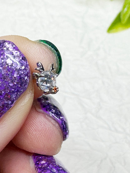 Reindeer barbell-ball earring size reference — small heart CZ and nose accent resting on fingertip