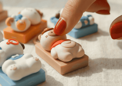 Hand pressing beige pig keycap keychain showing soft textured surface