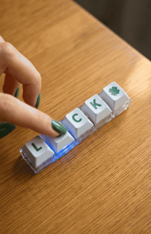 Animated GIF showing hand pressing LUCK mechanical keychain switches with LED lights turning on
