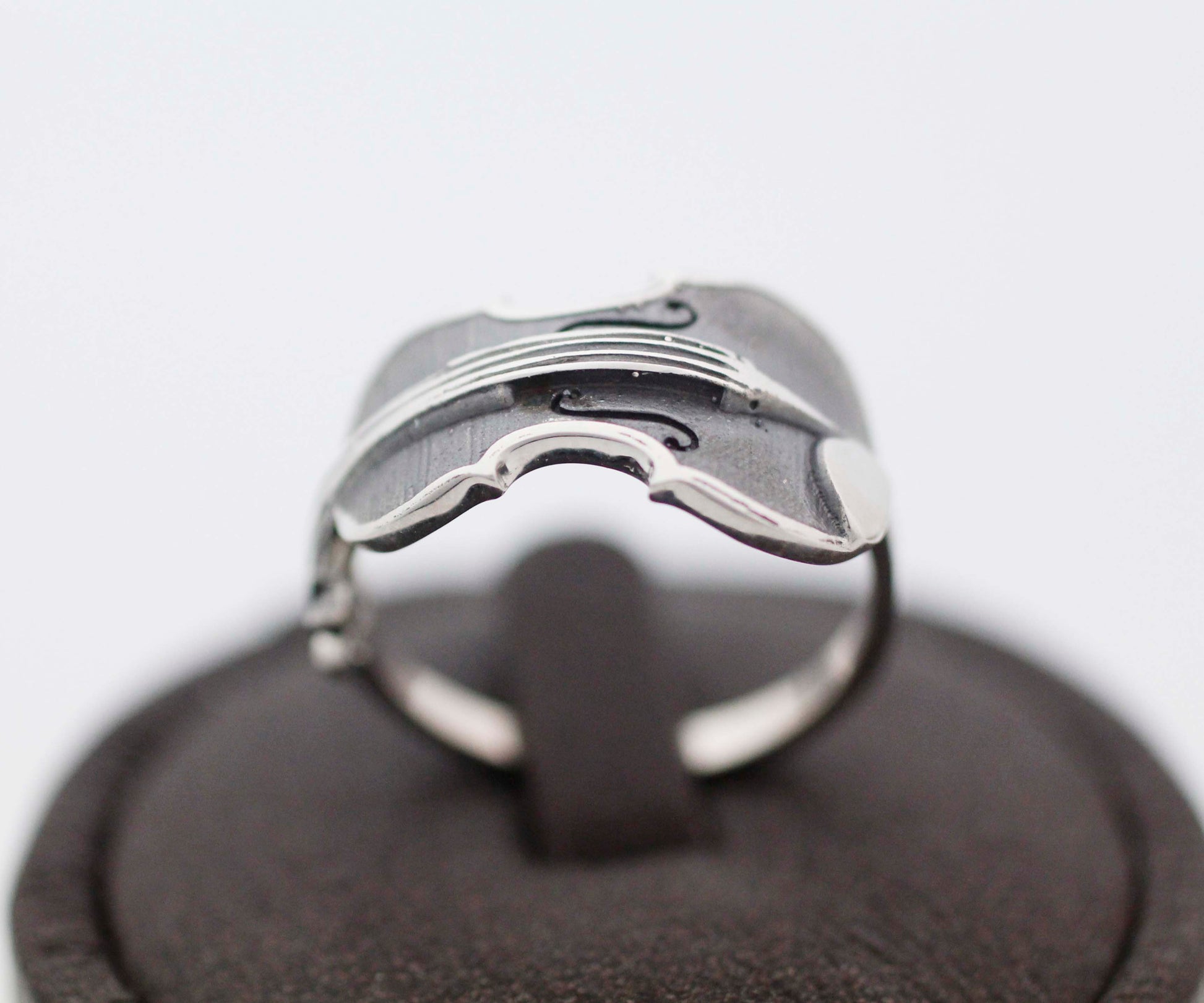 Handmade 925 silver violin ring with oxidized detailing on a dark display