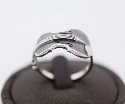 Handmade 925 silver violin ring with oxidized detailing on a dark display