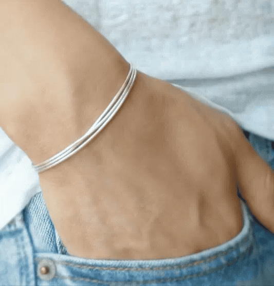 Woman wearing 925 sterling silver 3-strand snake chain bracelet with casual white tee and blue jeans