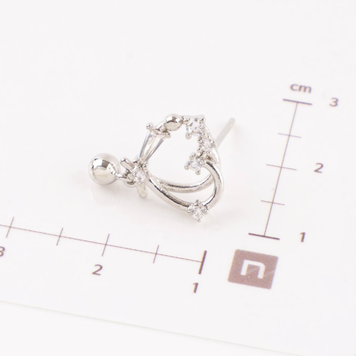 Silver heart earring next to ruler showing size scale, CZ crystal heart design with drop charm measuring approximately 2cm, lightweight dainty earrings, 925 sterling silver posts Korean made