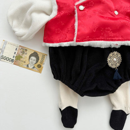 Korean traditional norigae ornament with navy tassel on Santa-style hanbok outfit, shown with Korean 50,000 won bill for size reference
