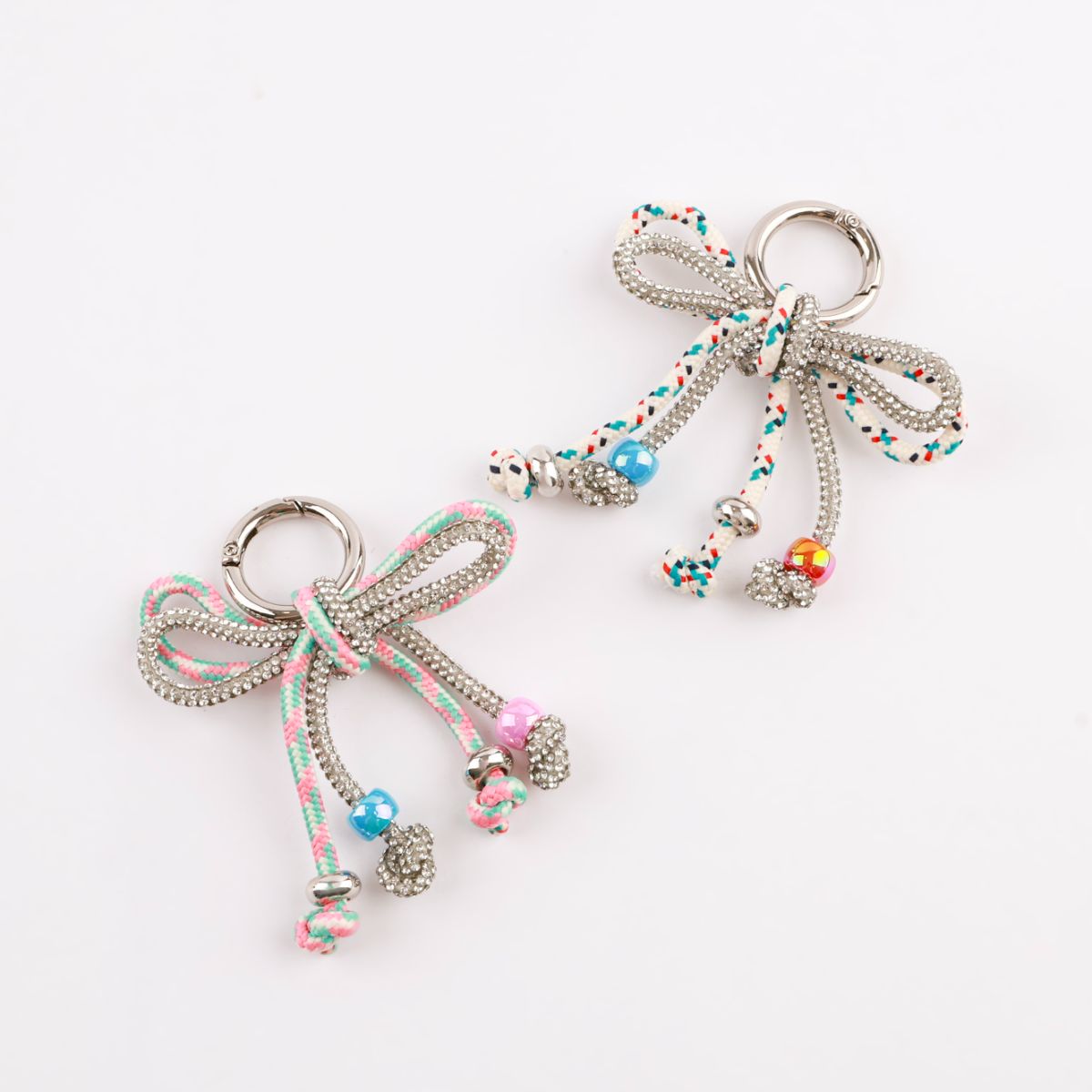 Two rhinestone rope bow bag charms in pink mint and white multi dot close-up comparison