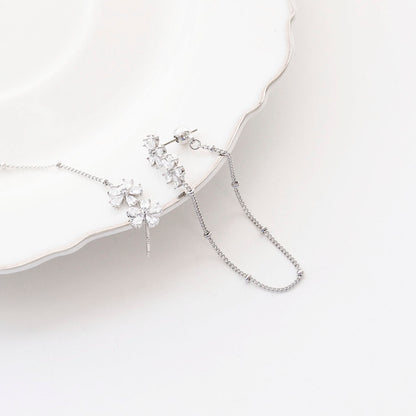 Flat lay of silver two-way floral crystal chain earrings on white background