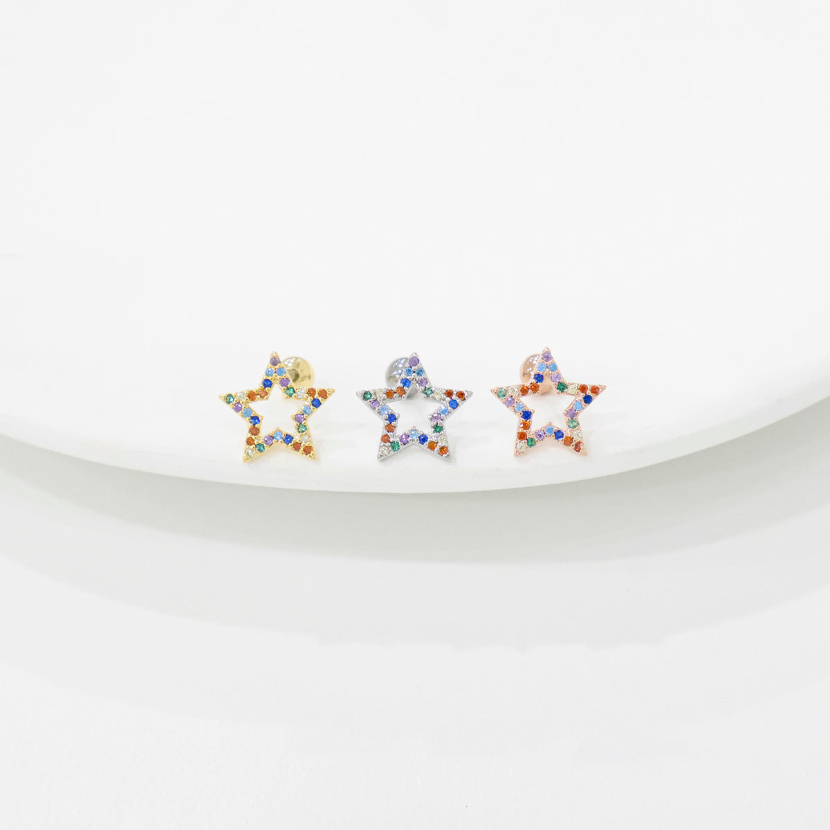 Rainbow CZ star piercings in three colors