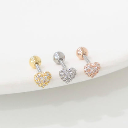Three pavé heart barbell earrings in gold, silver, and rose gold displayed on a white ceramic tray.
