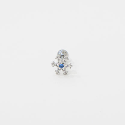 Single snowflake-shaped barbell piercing with blue cubic zirconia center, shown on white background.