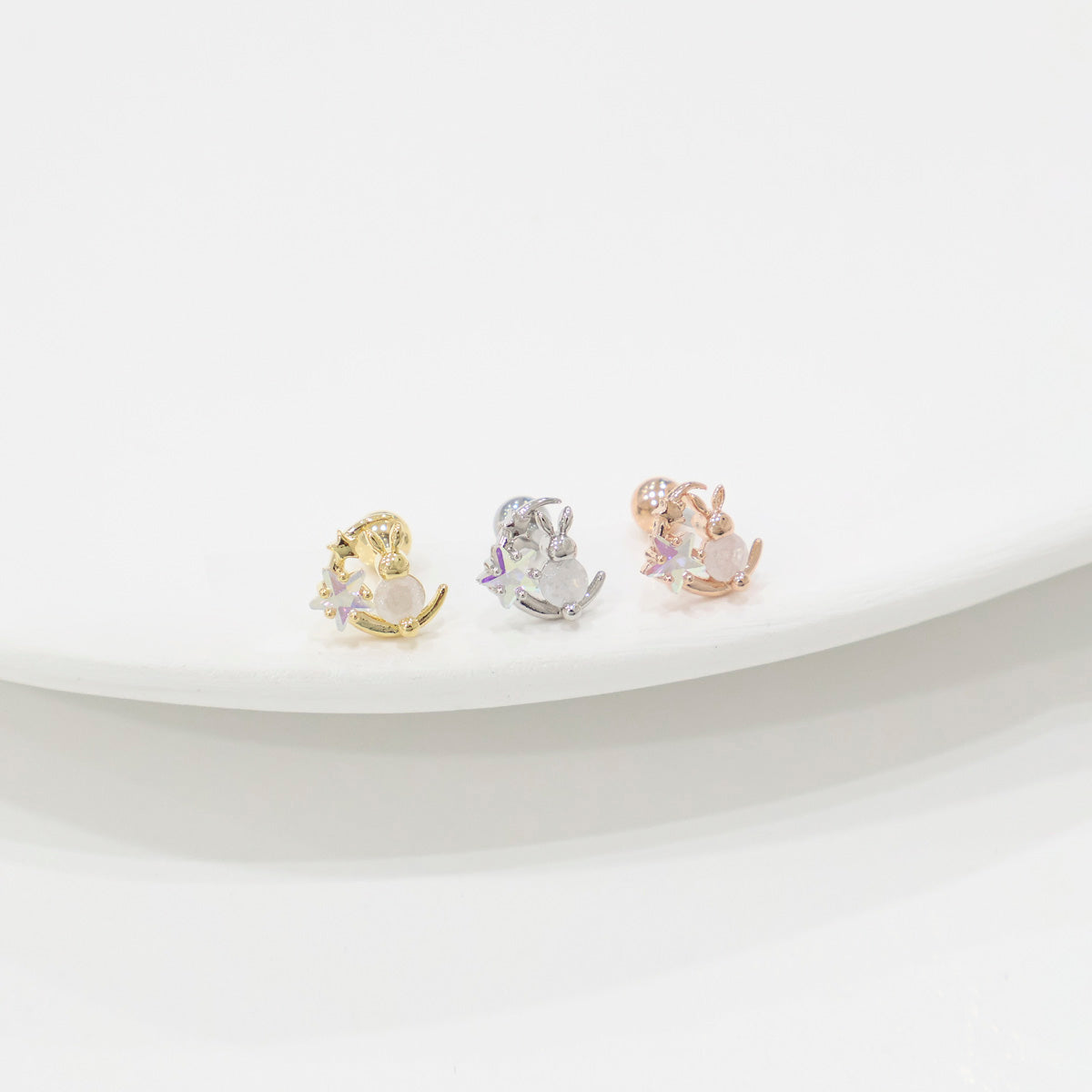 hree crescent moon rabbit piercing options in different metal finishes for cartilage placement