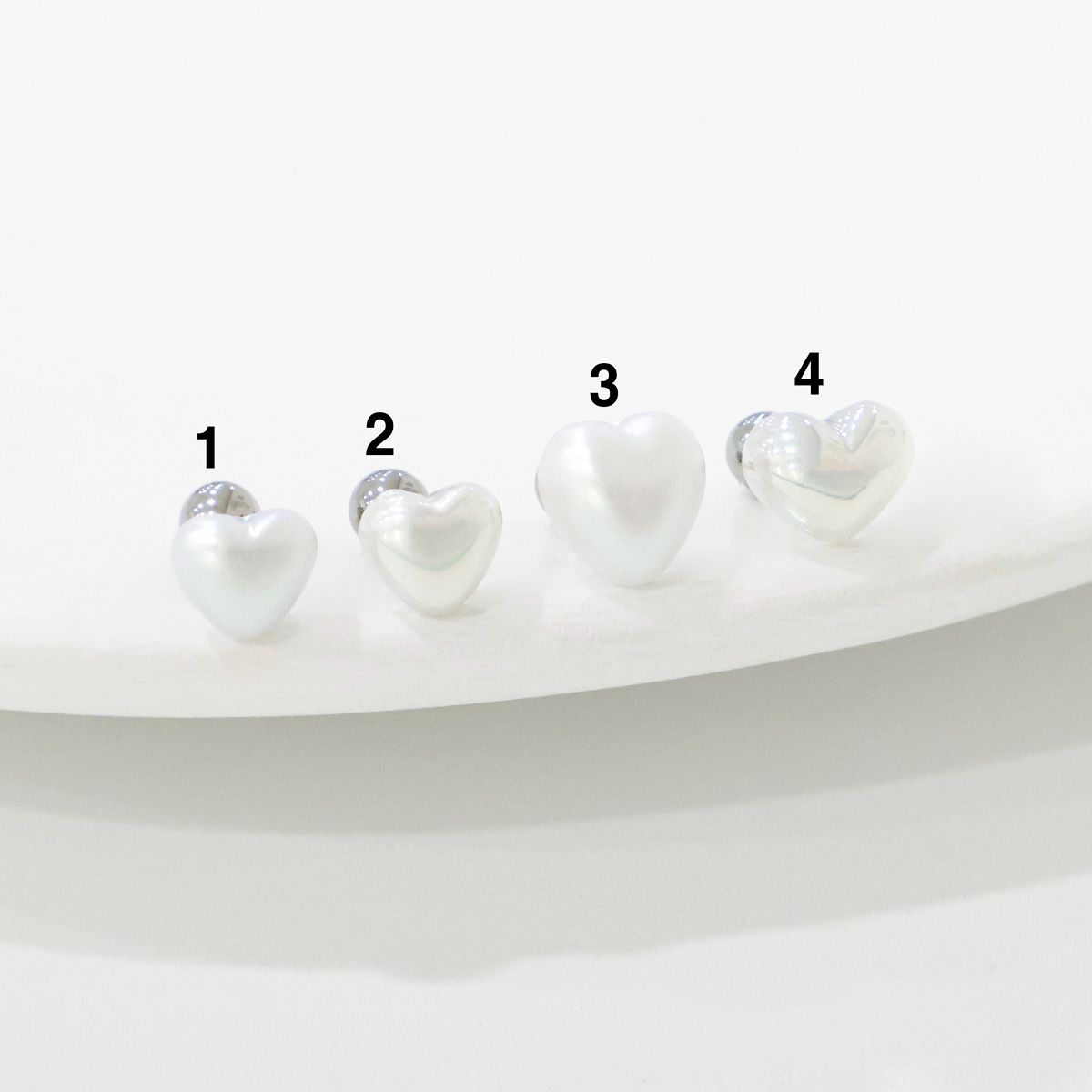 Four sizes of aurora heart pearl barbell studs comparison - sizes 1 through 4"