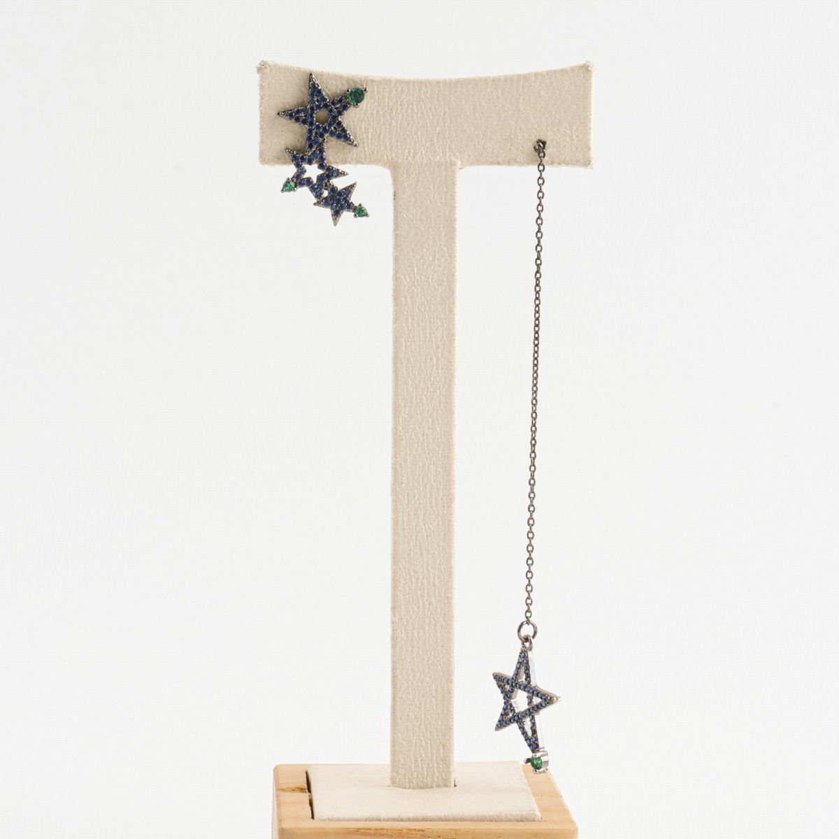 Blue pavé star earrings displayed on jewelry stand showing mismatch lengths


