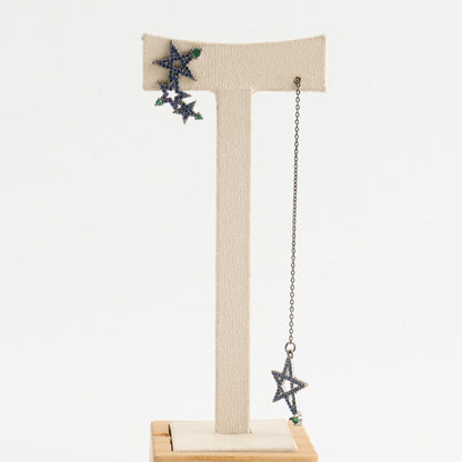 Blue pavé star earrings displayed on jewelry stand showing mismatch lengths


