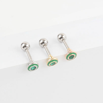 Close-up of green cubic cartilage earrings in three colors