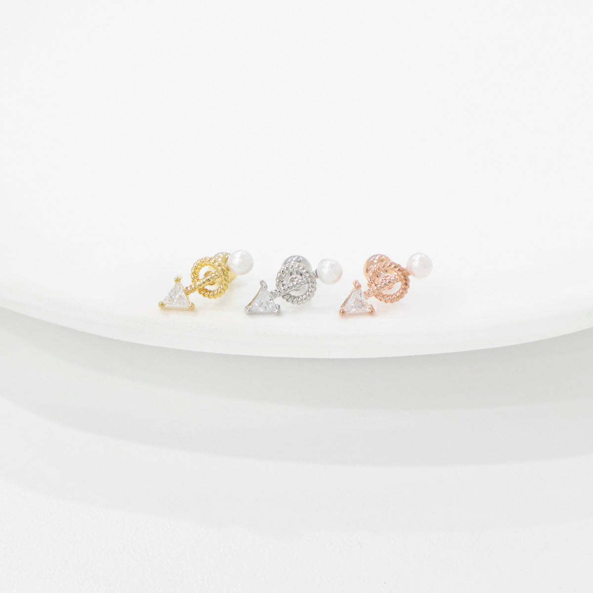 Product comparison photo of vintage pearl drop arrow barbell earrings in gold, silver, and rose gold finishes