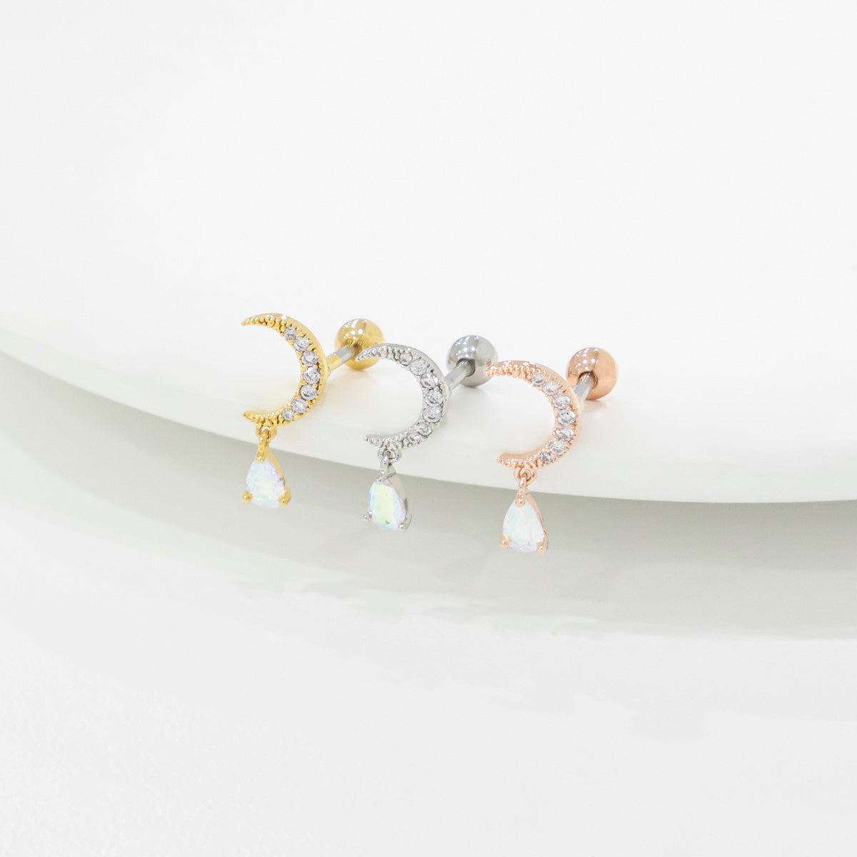 Angled view comparison of Gold, Silver, and Rose Gold crescent moon cartilage studs