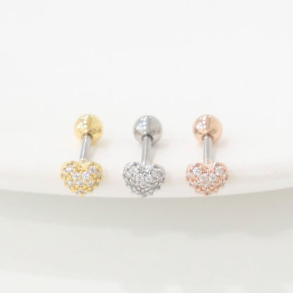 Gold, silver, and rose gold pavé heart earrings lined up on white surface, front-facing.
