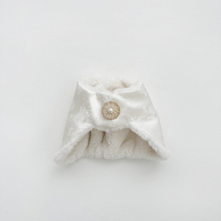 Close-up of a white Korean jobawi baby bonnet with floral jacquard satin and gold pearl brooch.
